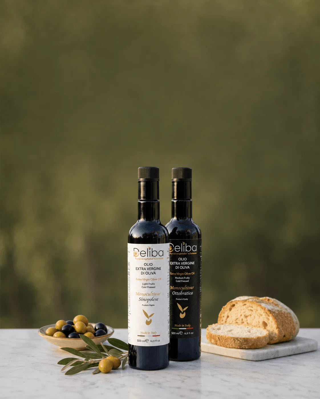 Deliba Ottobratico and Sinopolese extra virgin olive oils from Calabria, displayed with olives, olive branches and bread.